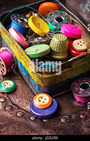 Retro buttons and thread in an old iron box Stock Photo
