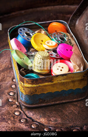 Old-fashioned metal box with buttons and threads Stock Photo