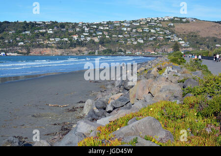 Christchurch, New Zealand - May 03, 2016; People strolling in the Autumn Sunshine on Sumner  Beach Promenade. In the background is Scarborough Hill. Stock Photo