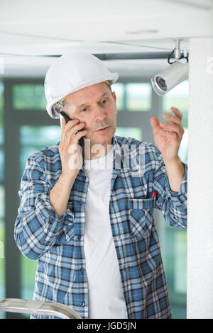 male technician encountering problems while installing camera Stock Photo