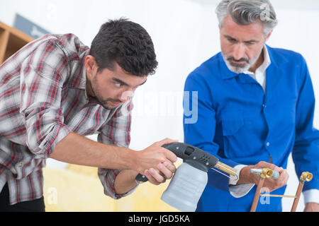 young plumber and supervisor using welding gas torch Stock Photo