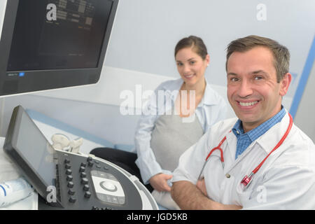 doctors using computer while man lying under xray machin Stock Photo