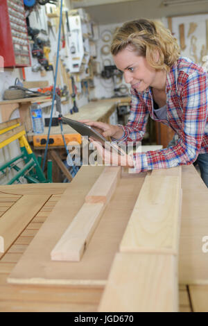 female carpenter accounting on tablet in her workshop Stock Photo