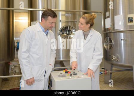apprentice and engineer using computer controlled machine Stock Photo
