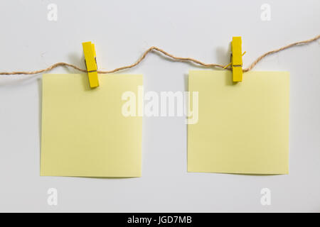 Clothespin hanging with blank note paper on white background. Stock Photo