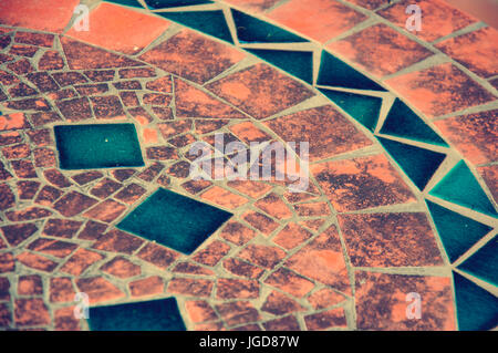A mosaic element on an old table, orange and blue. Stock Photo