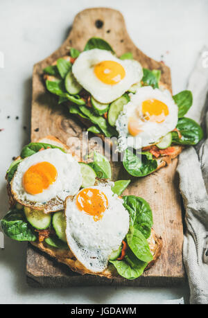Healthy breakfast sandwiches on rustic wooden board over grey background Stock Photo