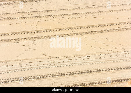 Traces of car tires on the sand as a background Stock Photo