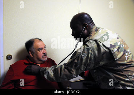 Lt. Col. Jude Momodu, a family physician and commander of 7229th Medical Support Unit located in Nashville, Tennessee, works with local residents at La Teresita community center.  Momodu is one of approximately 125 U.S. Army Reserve Soldiers who are working in partnership with the Texas A&M Colonias program to provide medical care to Webb County’s underserved colonias population.   Services provided by Army Reserve personnel are done through the Department of Defense’s Innovative Readiness Training, a civil-military program that builds mutually beneficial partnerships between U.S. communities  Stock Photo