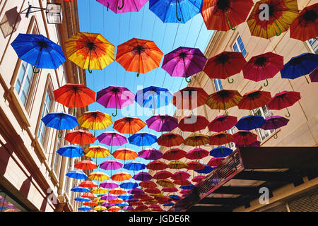 Colourful umbrellas suspended above a shopping street in Bath, UK Stock Photo