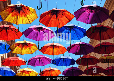 Colourful umbrellas suspended above a shopping street in Bath, UK Stock Photo