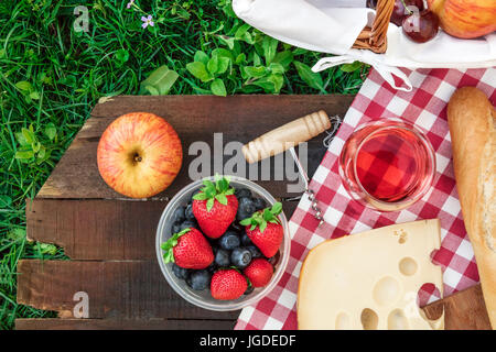 Picnic food and rose wine on wooden board with copyspace Stock Photo