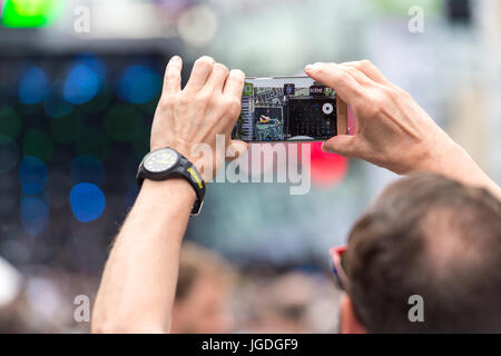Montreal, 2 July 2017: Man holding smart phone to film a concert at Montreal Jazz Festival Stock Photo