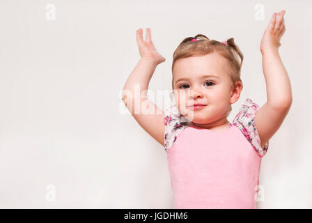 Portrait of a cute baby with raising hands up Stock Photo