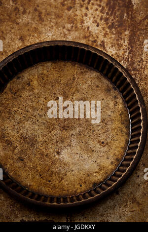 Vintage baking tart pan on aged metal sheet Stock Photo