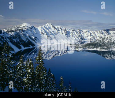 USA, Oregon, Crater Lake National Park, Winter snow on west rim of Crater Lake with The Watchman (left) and Hillman Peak (center). Stock Photo