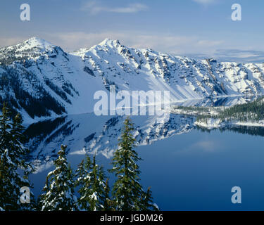 USA, Oregon, Crater Lake National Park, Winter snow on west rim of Crater Lake with The Watchman (left) and Hillman Peak (center). Stock Photo