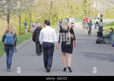 Kelvingrove park sunny scene people walking couple hand in hand eyes elsewhere Stock Photo