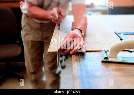 Midsection of Caucasian man cutting panel with saw Stock Photo