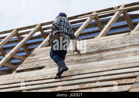 A man works on the construction of a wooden roof in the Maramures region, Romania Stock Photo