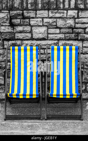 Empty yellow and blue striped deckchairs, Bournemouth, England Stock Photo