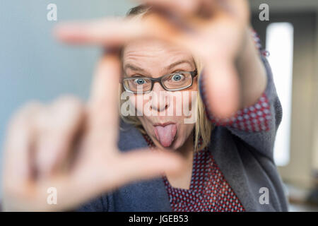 Woman with glasses sticks her tongue out Stock Photo