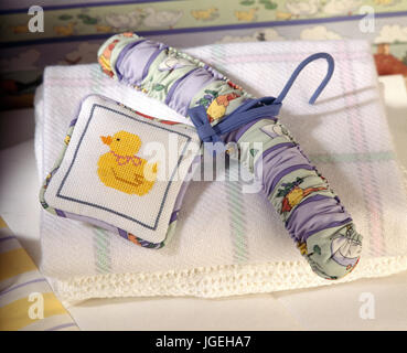 Fabric covered hanger for children's clothes with a cross stitch lavender bag Stock Photo