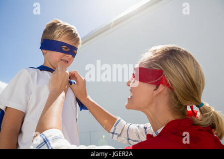 Mother and son pretending to be superhero in the backyard on a sunny day Stock Photo