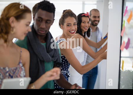 Team of executives writing on sticky notes in the office Stock Photo