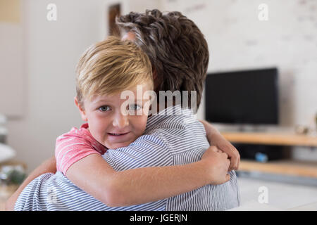 Happy father and son embracing each other in living room at home Stock Photo