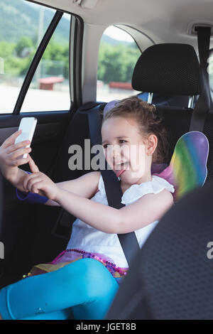 Cute girl taking selfie from mobile phone in car Stock Photo