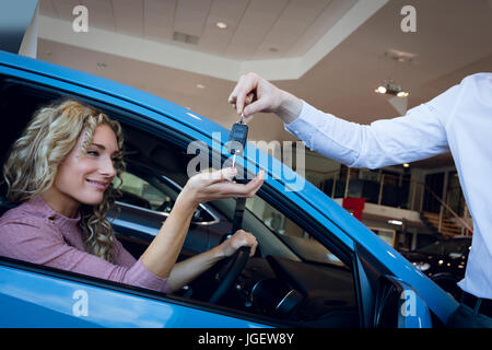 Cropped image of salesman giving keys to customer Stock Photo