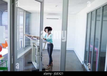 Female architect working on blueprint over drafting table in office Stock Photo
