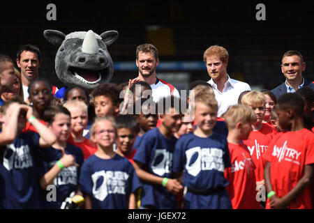 Prince Harry with mascot Ronnie the Rhino, rugby league player Sean O'Loughlin (third right), former Leeds Rhino rugby league player Kevin Sinfield (right) and schoolchildren during his visit to the Headingley Carnegie Stadium in Leeds, on the first day of his two-day visit to the city. Stock Photo