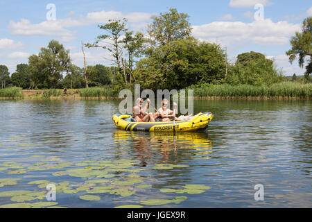 A midle aged couple rowing an inflatable canoe on the River Thames at Wallingford, Oxfordshire England UK Stock Photo