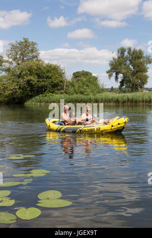 A midle aged couple rowing an inflatable canoe on the River Thames at Wallingford, Oxfordshire England UK Stock Photo