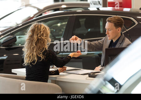 Salesman giving keys to female customer Stock Photo