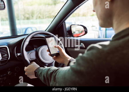 Midsection of man using mobile phone in car Stock Photo