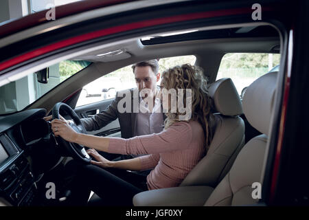 Salesperson assisting woman sitting in car Stock Photo