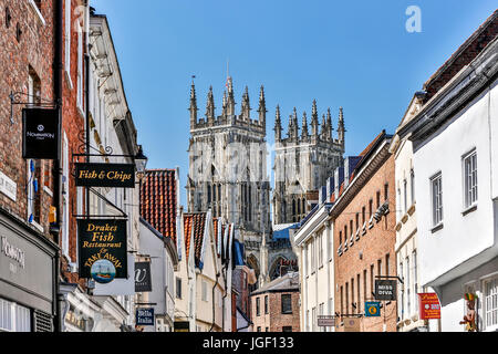 Shops, signs and towers of York Minster (The Cathedral and Metropolitical Church of Saint Peter) in background, York, Yorkshire, England, United Kingd Stock Photo