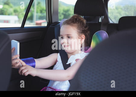 Cute girl taking selfie from mobile phone in car Stock Photo