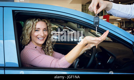 Cropped image of hand giving keys to customer Stock Photo