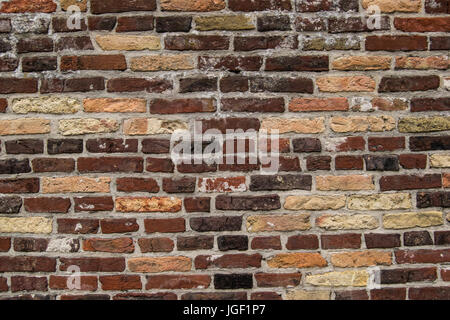 An old weathered brick wall background with multi-colored bricks Stock Photo
