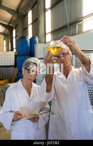 Technicians examining olive oil in factory Stock Photo