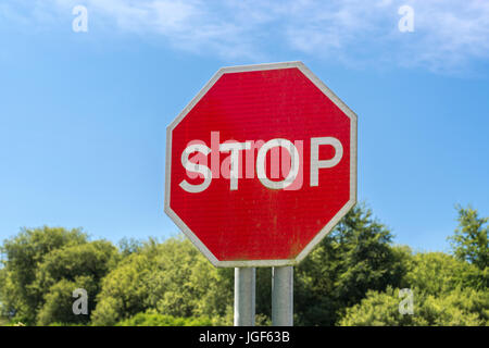 Octagonal red traffic stop sign seen against blue summer sky. Possible metaphor for US government shutdown. Metaphor for 'obey', end of the road. Stock Photo