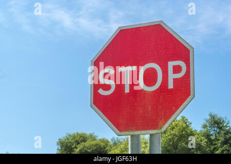 Octagonal red traffic stop sign seen against blue summer sky. Possible metaphor for US government shutdown. Metaphor for 'obey', end of the road. Stock Photo
