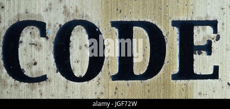 Word "code" in black letters isolated on rusty metal background Stock Photo