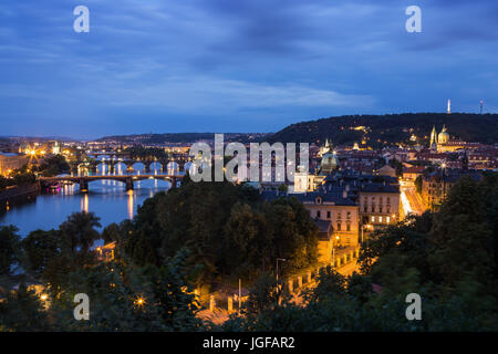 Lit bridges over Vltava River and buildings at the Mala Strana District (Lesser Town) in Prague, Czech Republic, viewed slightly from above at dusk. Stock Photo