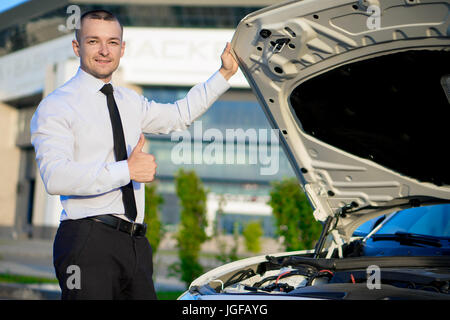 man in a shirt next to the car Stock Photo