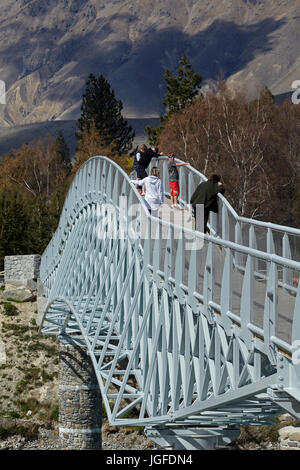 Tourists on pedestrian Bridge over Lake Tekapo outlet to Church of the Good Shepherd,  Mackenzie Country, Canterbury, South Island, New Zealand Stock Photo